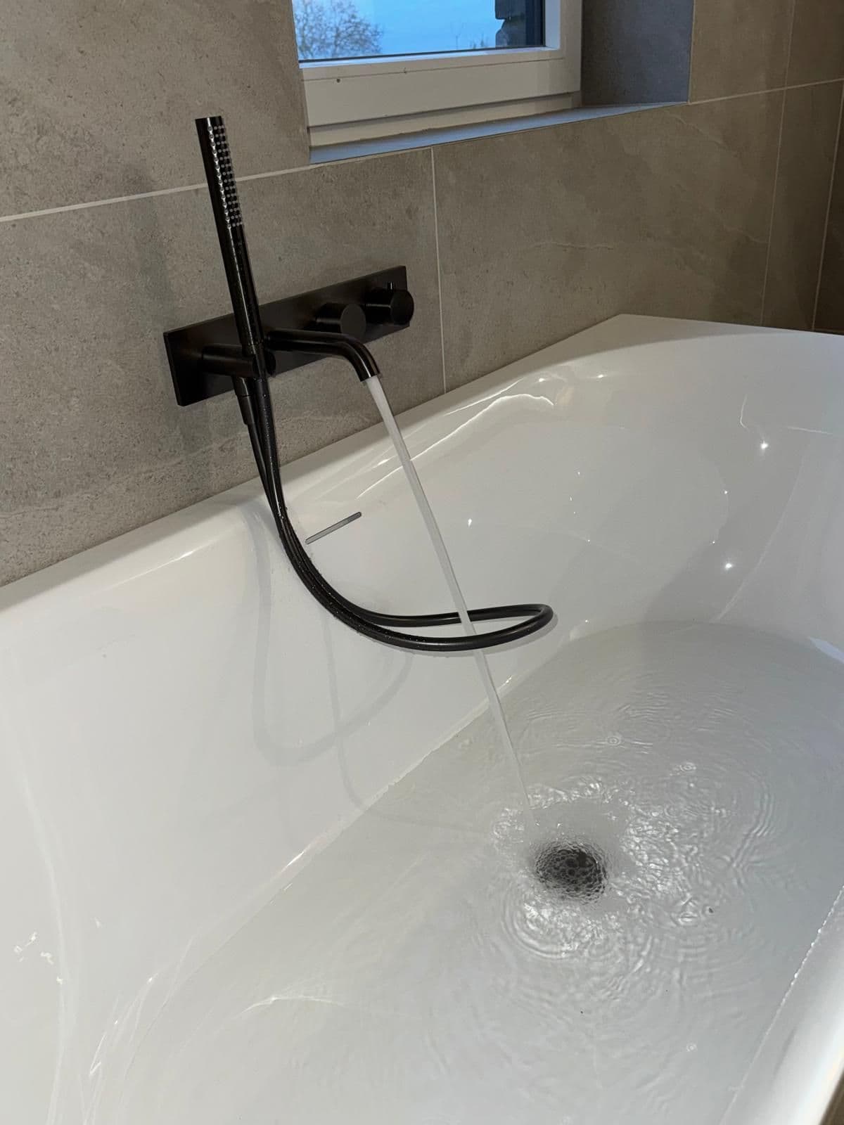 Baignoire avec robinetterie noire, remplissage en cours