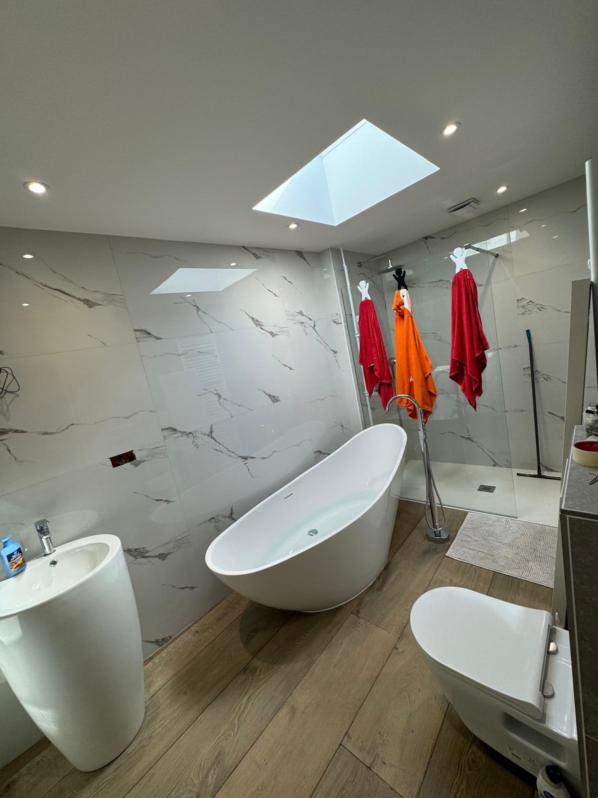 Baignoire îlot et douche à l'italienne en marbre, avec puits de lumière